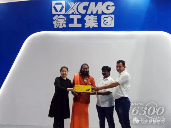 工作人員向購機(jī)客戶贈送徐工產(chǎn)品模型