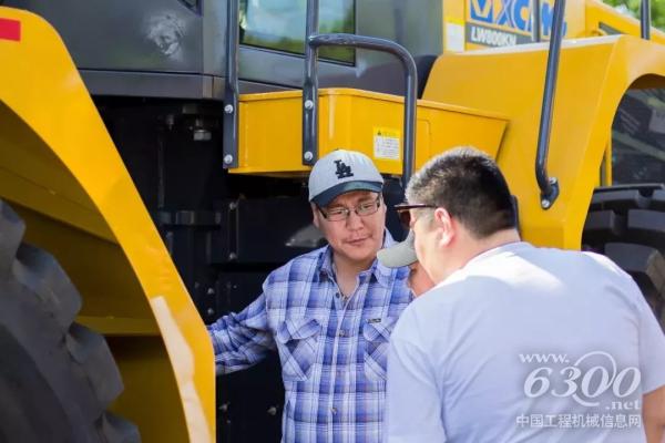 客戶仔細(xì)觀察裝載機(jī)，并不斷向工作人員詢問其性能參數(shù)